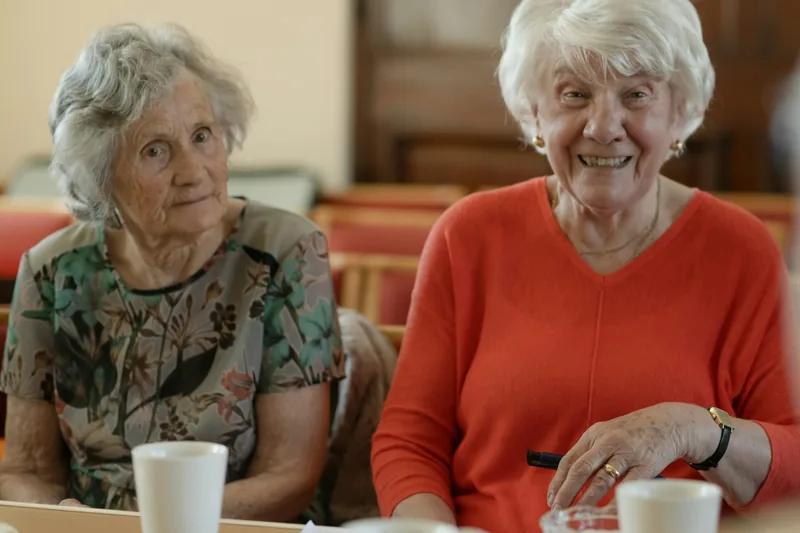 Zwei ältere Damen mit Kaffee am Tisch im Café