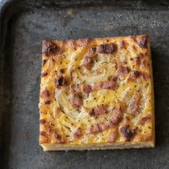 Stück Zwiebelkuchen mit goldener Oberfläche
