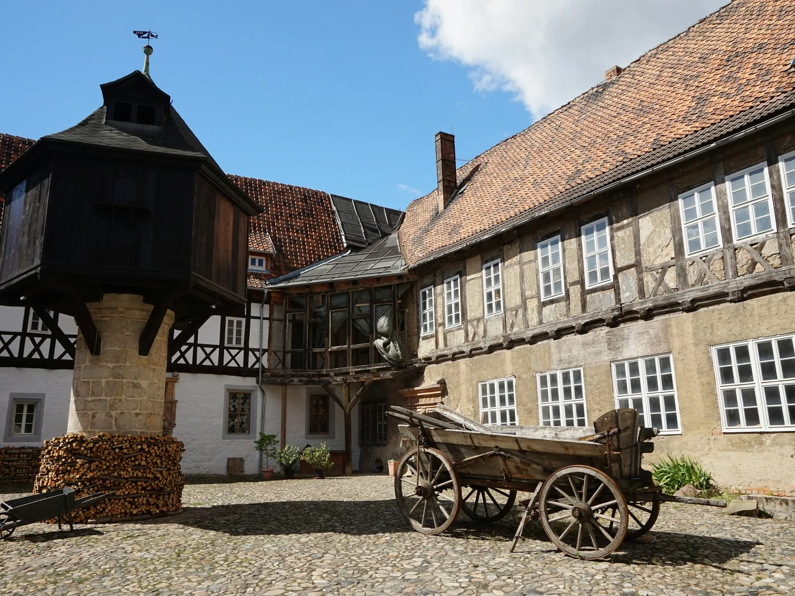 Gepflasterter Hof eines sanierten Bauernhauses mit Fachwerk und Taubenhaus