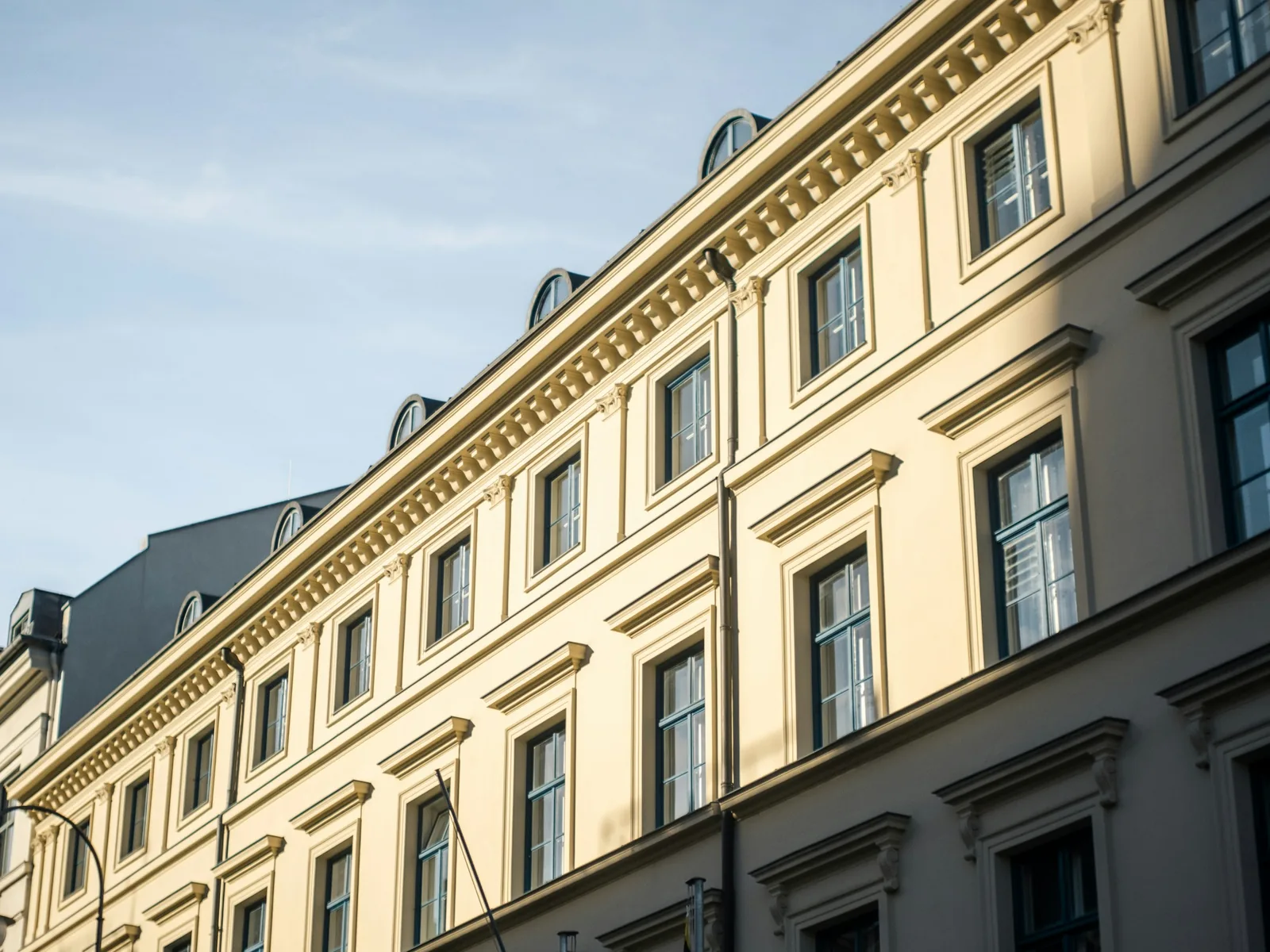 Sanierte Altbaufassade mit Stuckgesimsen in der Sonne