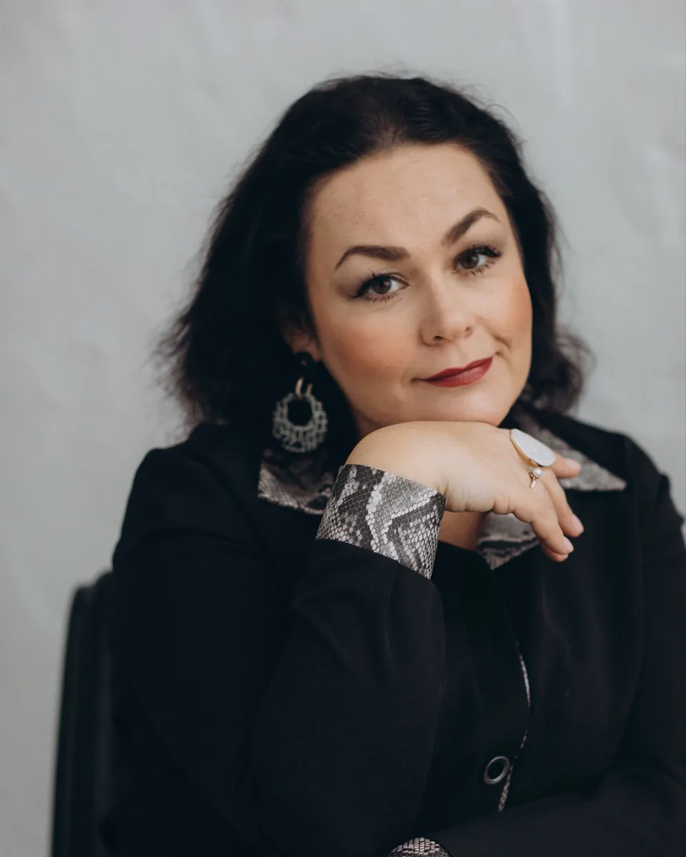 Sabine Petzold mit dunklem Haar, das Kinn auf die Hand gestützt